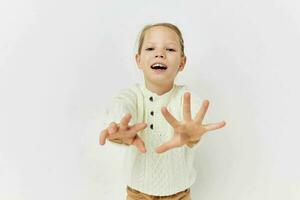 pequeno menina dentro uma branco suéter à moda roupas luz fundo foto