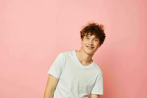 retrato do uma jovem encaracolado homem verão roupas branco camiseta posando estilo de vida inalterado foto