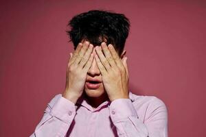 retrato do uma jovem homem posando moda Rosa camisa moderno estilo Rosa fundo inalterado foto