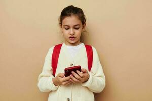 fofa menina com telefone posando vermelho mochila estilo de vida inalterado foto