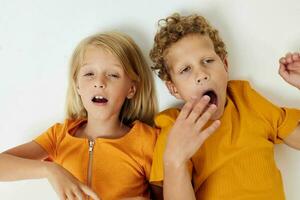 engraçado crianças Garoto e menina dentro amarelo Camisetas estúdio luz fundo foto
