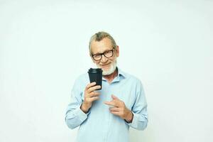 velho homem com uma Preto vidro dentro dele mãos uma beber isolado fundo foto