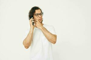 alegre homem dentro uma branco camiseta comunicação de telefone isolado fundo foto