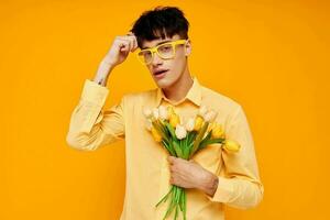 foto do romântico jovem namorado dentro amarelo óculos com uma ramalhete do flores estilo de vida inalterado