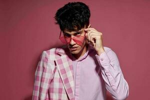 uma jovem homem auto confiança Rosa xadrez blazer moda posando Rosa fundo inalterado foto