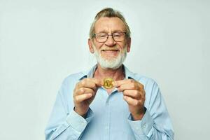 retrato do feliz Senior homem finança ouro moedas bitcoin posando inalterado foto