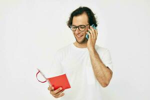 bonito homem falando em a telefone vermelho bloco de anotações isolado fundo foto