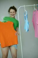 engraçado menina tentando em roupas guarda roupa juventude estilo isolado fundos inalterado foto