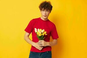 retrato do uma jovem encaracolado homem dentro uma vermelho camiseta uma ramalhete do flores feriado presente monocromático tiro foto