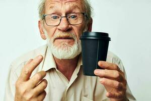 Senior grisalho homem com uma cinzento barba dentro uma camisa e óculos cortada Visão foto