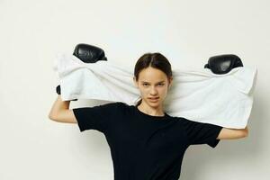 jovem lindo mulher com toalha boxe Preto luvas posando Esportes isolado fundo foto