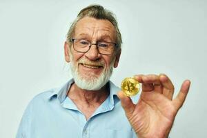 retrato do feliz Senior homem finança ouro moedas bitcoin posando inalterado foto