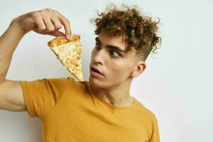 atraente homem comendo pizza posando fechar-se isolado fundo foto