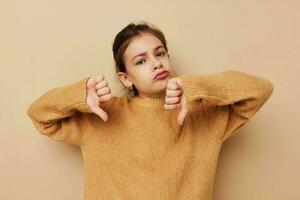 bonita jovem menina dentro suéter posando mão gestos isolado fundo foto