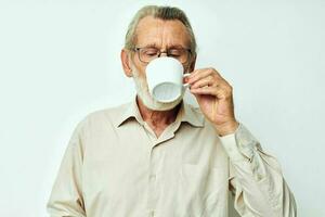 idosos homem bebendo a partir de uma caneca em uma branco fundo e sorridente foto