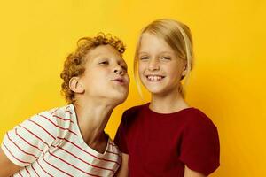 fofa pré escola crianças em pé lado de lado posando infância emoções amarelo fundo foto