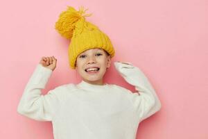retrato do feliz sorridente criança menina Diversão dentro uma amarelo chapéu Diversão Rosa fundo foto