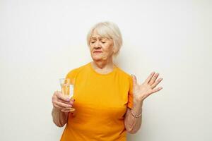 retrato do a velho amigáveis mulher dentro casual camiseta óculos vidro do água cortada Visão foto