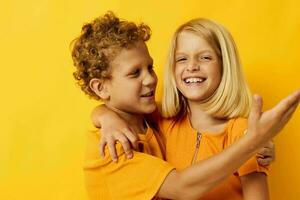 fofa à moda crianças dentro amarelo Camisetas em pé lado de lado infância emoções isolado fundo foto