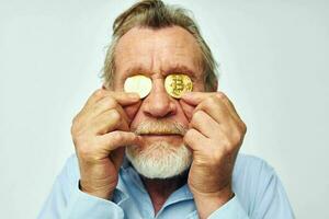 Senior grisalho homem dentro uma azul camisa bitcoins em a face isolado fundo foto
