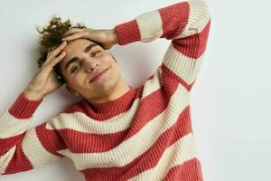bonito jovem homem dentro uma listrado suéter posando estilo de vida inalterado foto