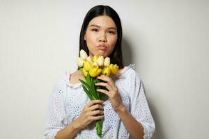 mulher com uma ramalhete do flores sorrir fechar-se luz fundo inalterado foto