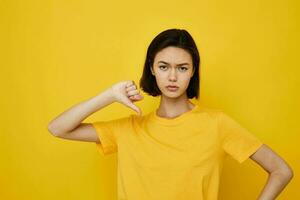 otimista jovem mulher dentro amarelo camiseta posando moda estilo de vida inalterado foto