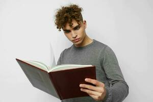 jovem cara com livro Aprendendo Educação posando foto