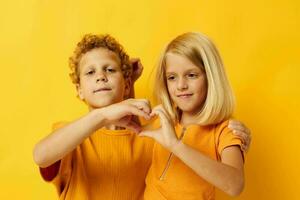 fofa pré escola crianças dentro amarelo Camisetas em pé lado de lado infância emoções amarelo fundo foto