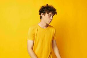 jovem cabelo encaracolado homem vestindo à moda amarelo camiseta posando estilo de vida inalterado foto