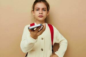 retrato do feliz sorridente criança menina estudante mochila telefone dentro mão infância inalterado foto