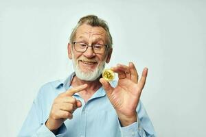 retrato do feliz Senior homem finança ouro moedas bitcoin posando inalterado foto