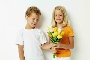 dois alegre crianças com uma ramalhete do flores presente aniversário feriado infância luz fundo foto