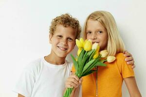 dois alegre crianças Diversão aniversário presente surpresa ramalhete do flores isolado fundo inalterado foto