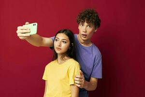 jovem homem e menina moderno estilo emoções Diversão telefone vermelho fundo foto