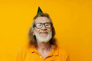 retrato do feliz Senior homem dentro uma amarelo camiseta com uma boné em dele cabeça Diversão amarelo fundo foto