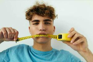 bonito jovem homem azul camiseta medindo fita posando isolado fundo foto