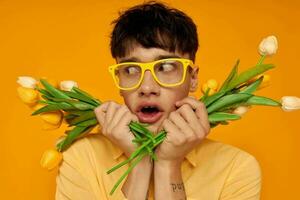 foto do romântico jovem namorado dentro amarelo óculos com uma ramalhete do flores estilo de vida inalterado