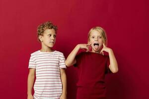 Garoto e menina emoções ficar de pé lado de lado dentro todo dia roupas em colori fundo inalterado foto