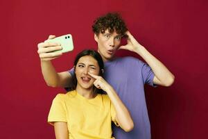 jovem homem e menina dentro colorida Camisetas com uma telefone juventude estilo foto