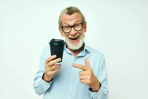 retrato do feliz Senior homem com uma Preto vidro dentro dele mãos uma beber isolado fundo foto