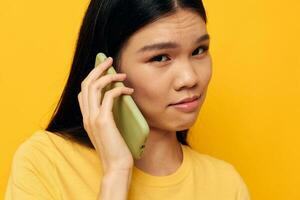 bonita morena telefone comunicação Diversão usar amarelo fundo inalterado foto