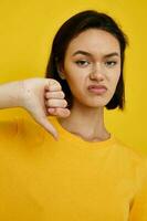 curto cabelos morena amarelo camiseta verão estilo mão gesto amarelo fundo foto