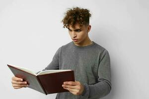 jovem cara com livro Aprendendo Educação posando foto