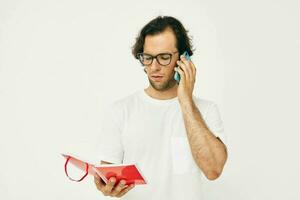 homem falando em a telefone vermelho bloco de anotações isolado fundo foto