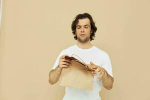 atraente homem dentro uma branco camiseta com papel saco isolado fundo foto