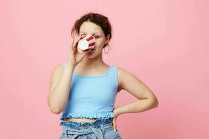 menina bebendo uma beber descartável vidro Rosa fundo inalterado foto