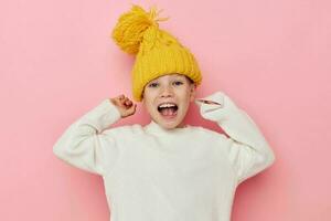 retrato do feliz sorridente criança menina dentro uma suéter e uma chapéu infância inalterado foto