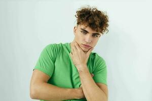 bonito jovem homem dentro verde Camisetas emoções posando estilo de vida inalterado foto