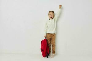 pequeno menina vermelho mochila à moda roupas isolado fundo foto